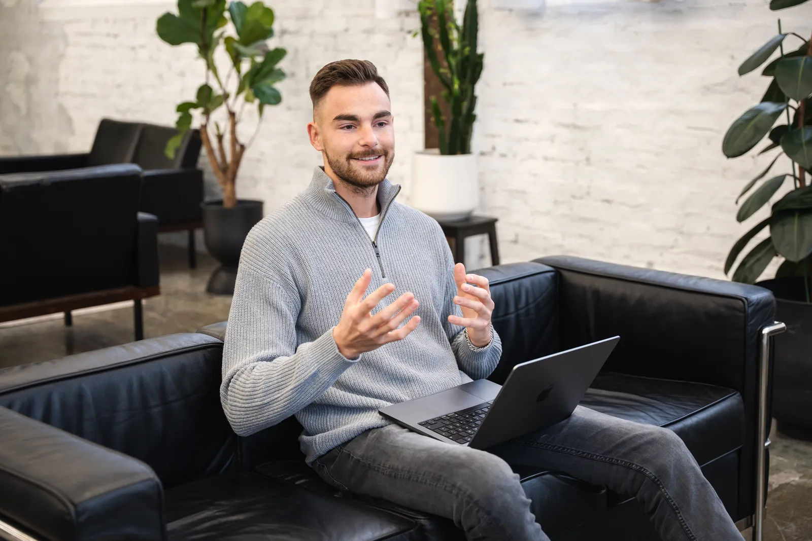 Jan Philipps sitzt mit dem Laptop auf dem Sofa und erklärt etwas