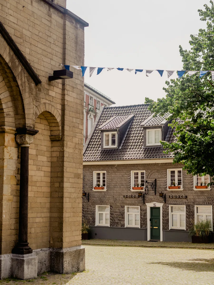 Altes Schieferhaus in der Mettmanner Altstadt, darueber eine Wimpelkette