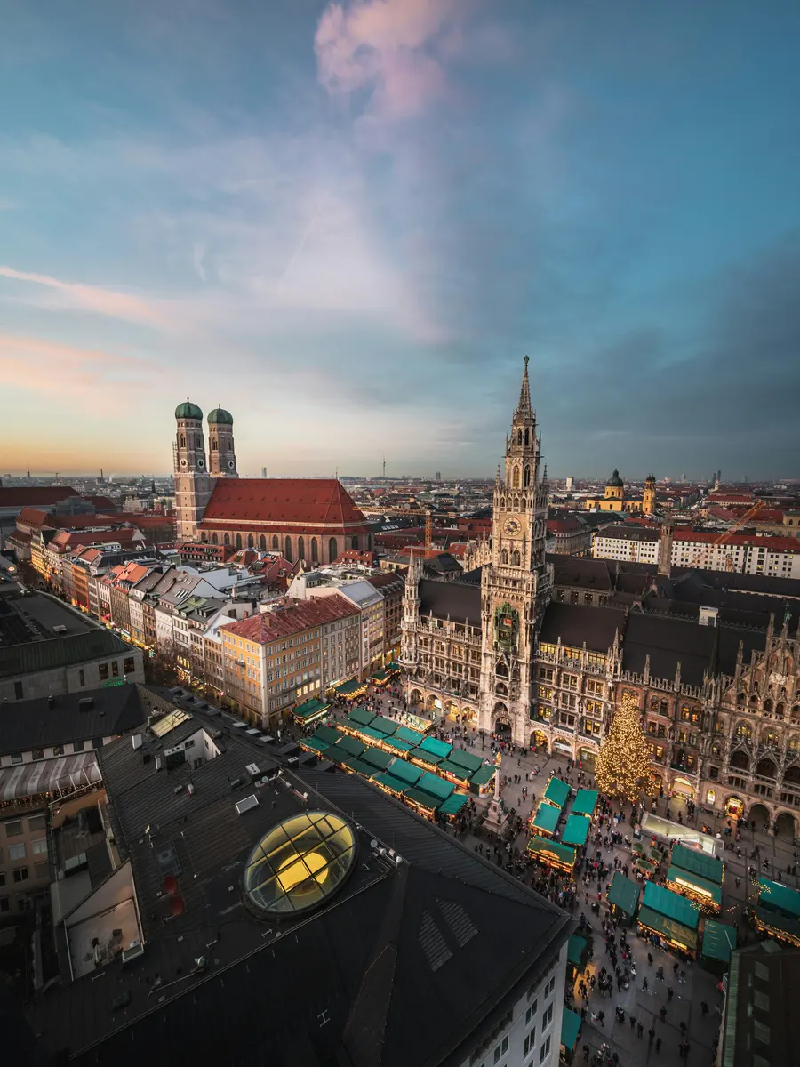 Blick über die Münchner Altstadt mit Frauenkirche und Neuem Rathaus in der Dämmerung